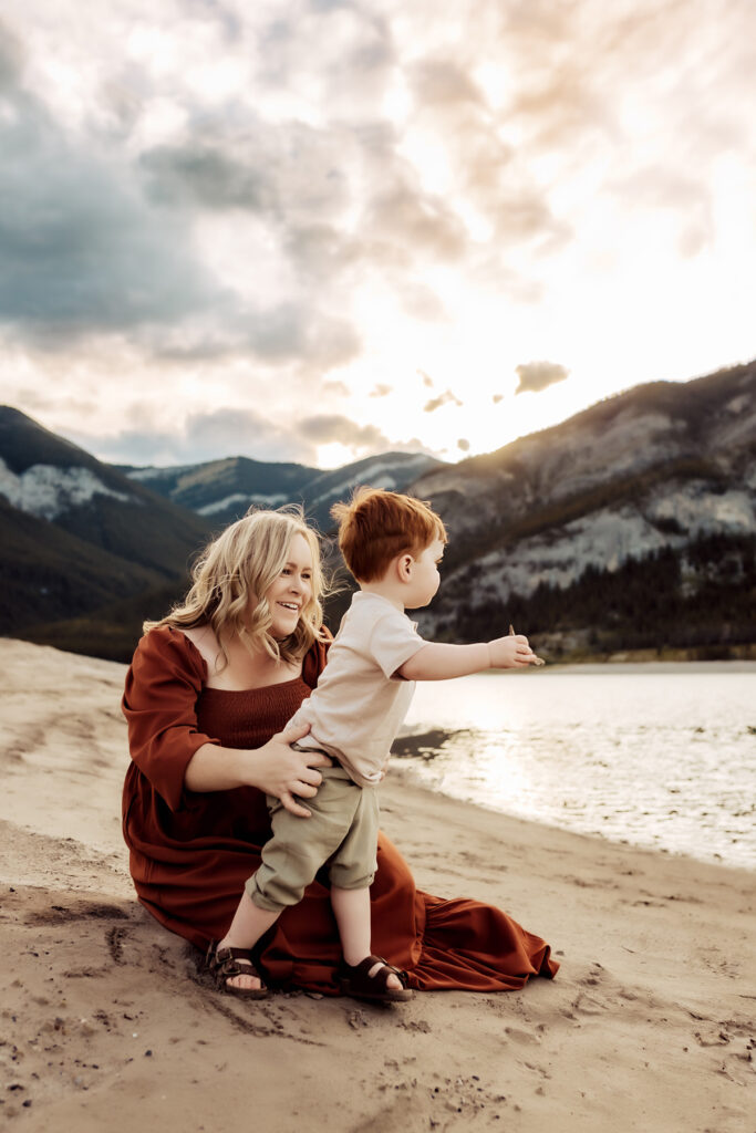 Family Photographer, a mother admires her young son near a quiet river