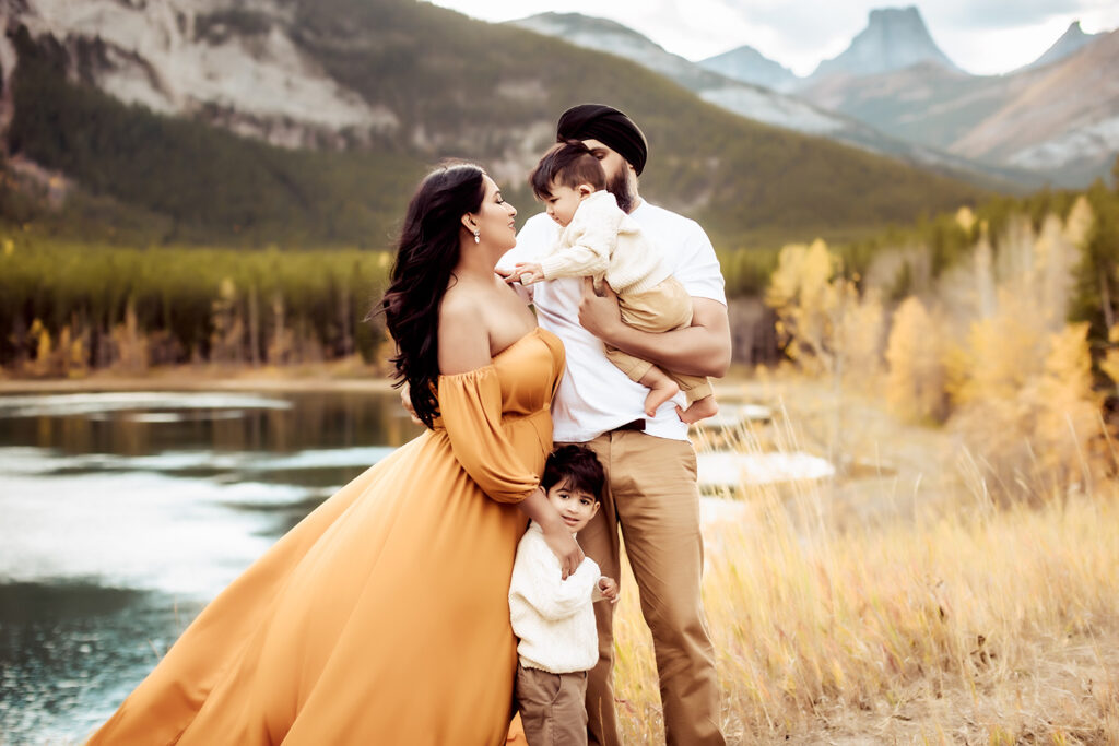 Family Photographer, a man and woman stand together with their children near a quiet river